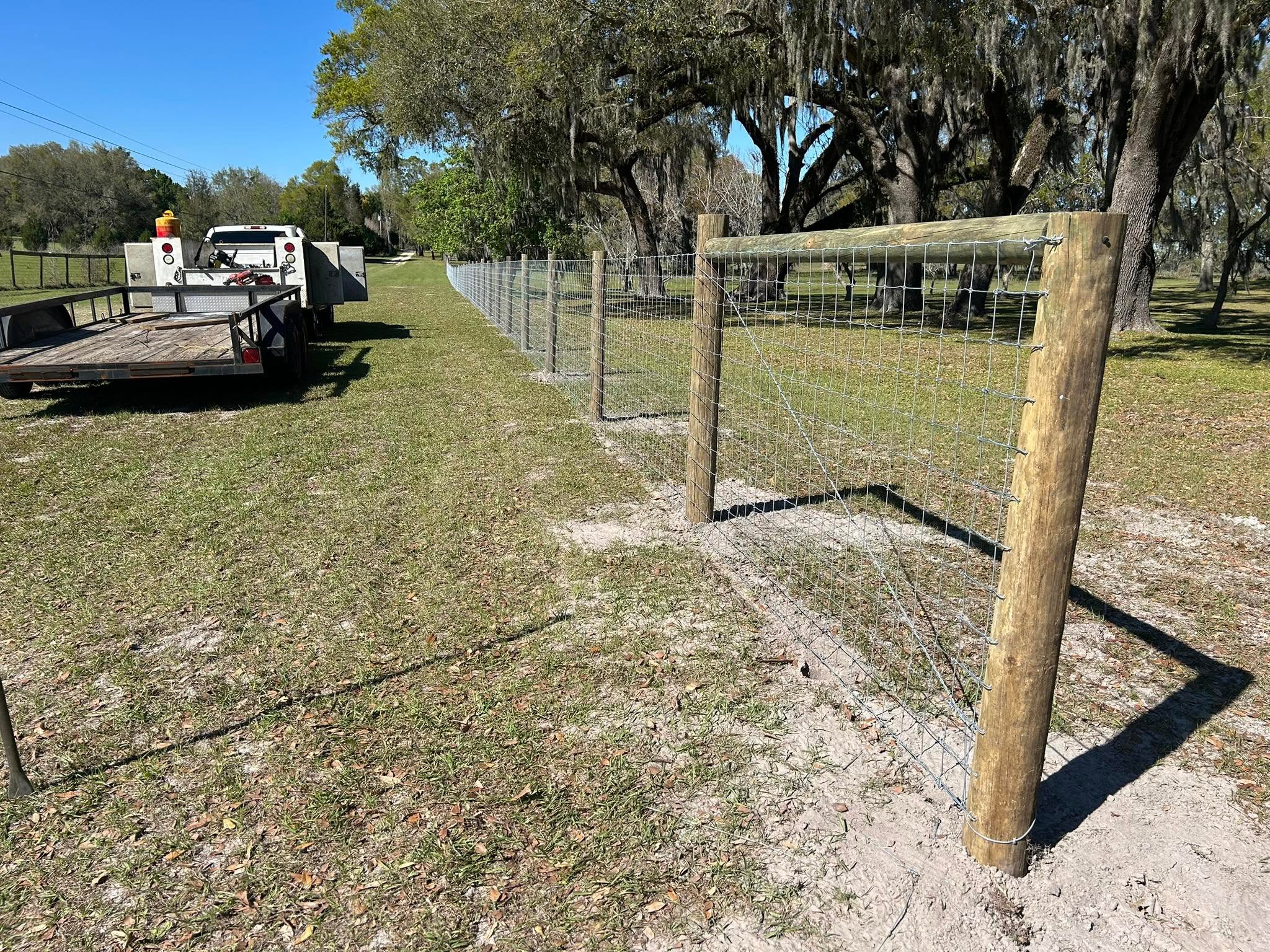 Woven-wire agricultural fence with wood posts