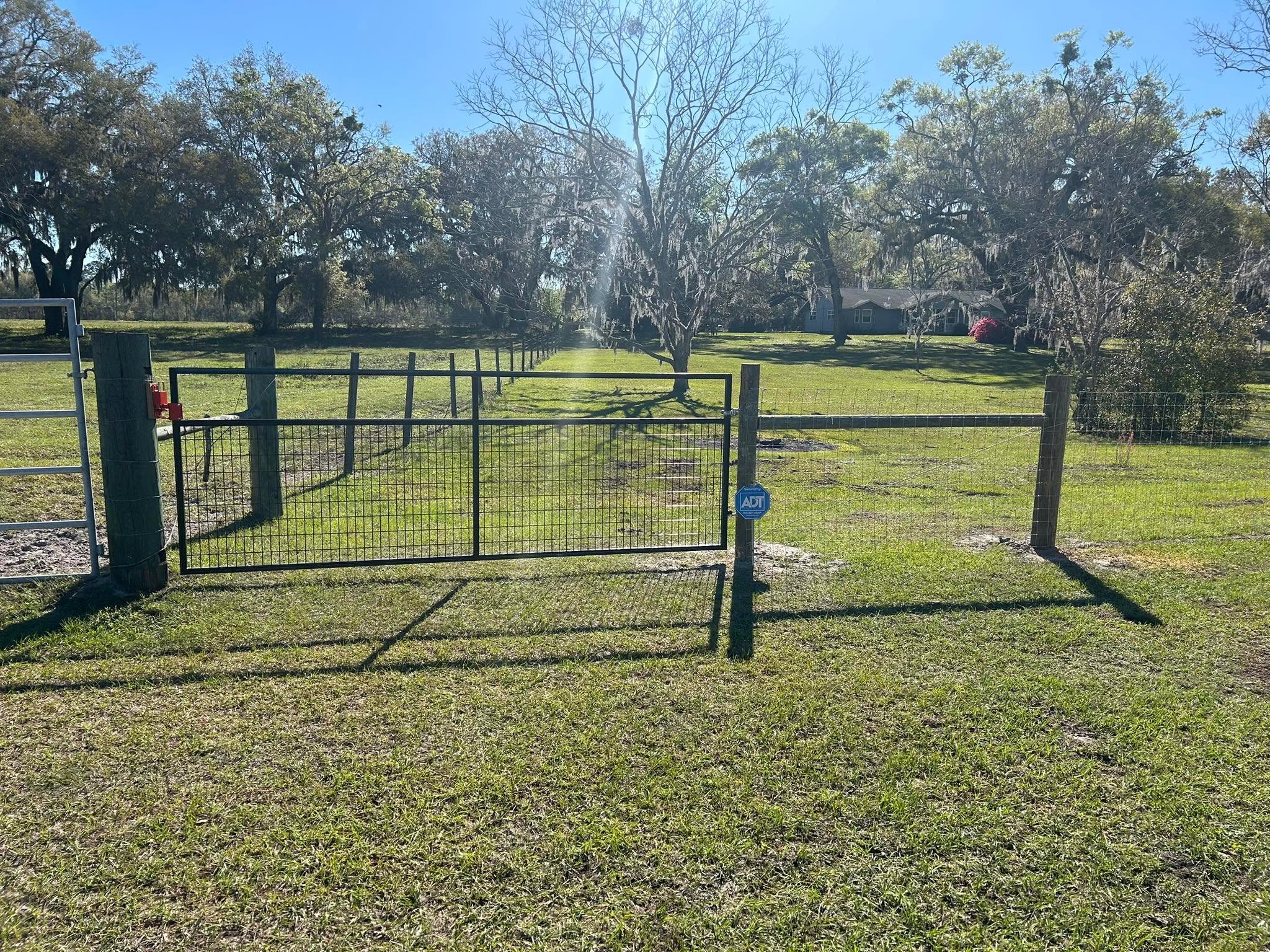 Black metal farm gate across a rural property entrance