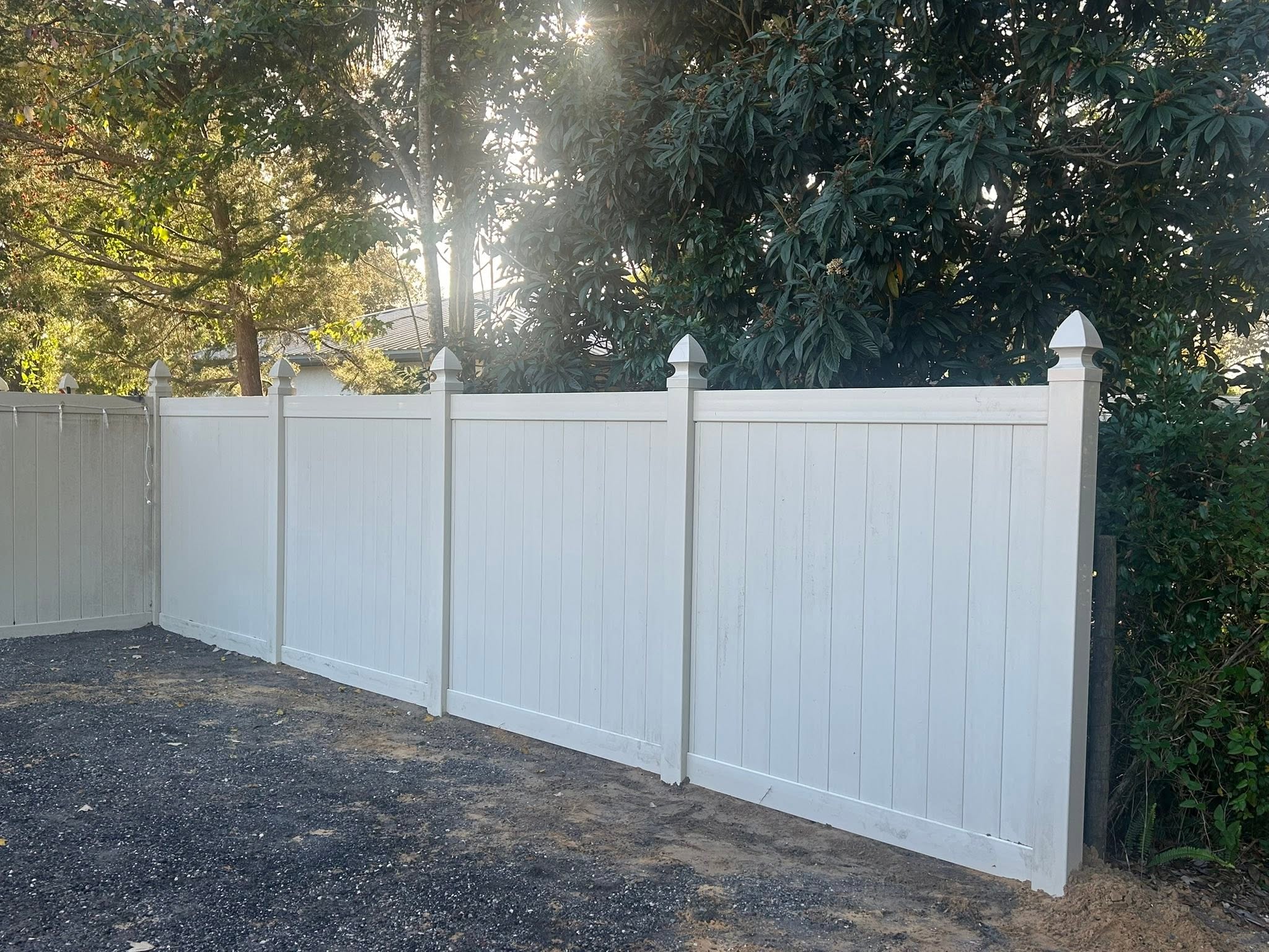 White vinyl privacy fence with decorative post caps